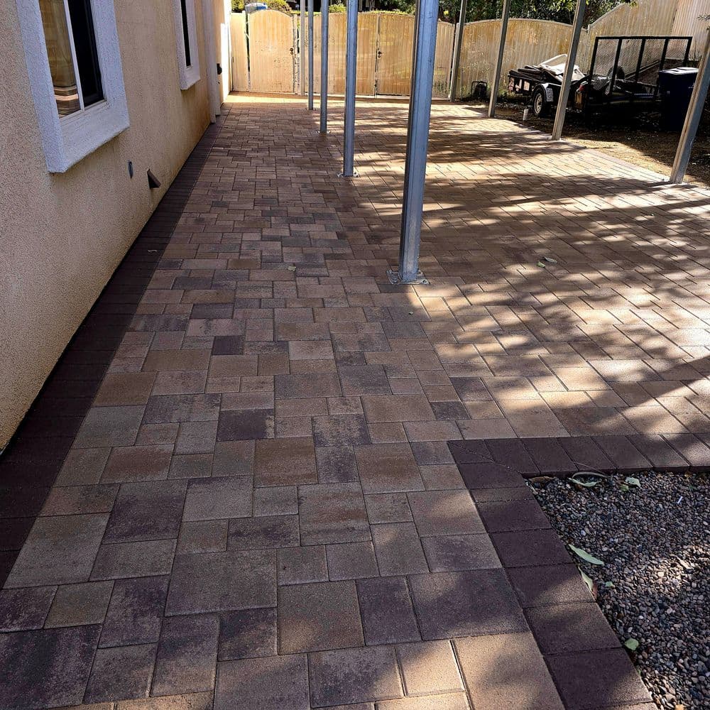Paved outdoor patio area with stone tiles and metal support posts.