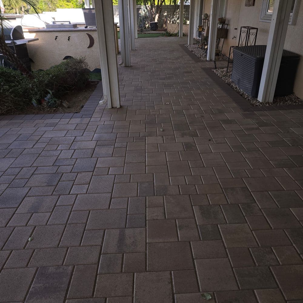 Paved walkway with rectangular stone tiles in a covered outdoor area.